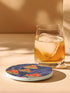 Round ceramic coaster featuring orange and yellow mushrooms with striped caps against a dark background with flowing purple lines in a psychedelic 70s style